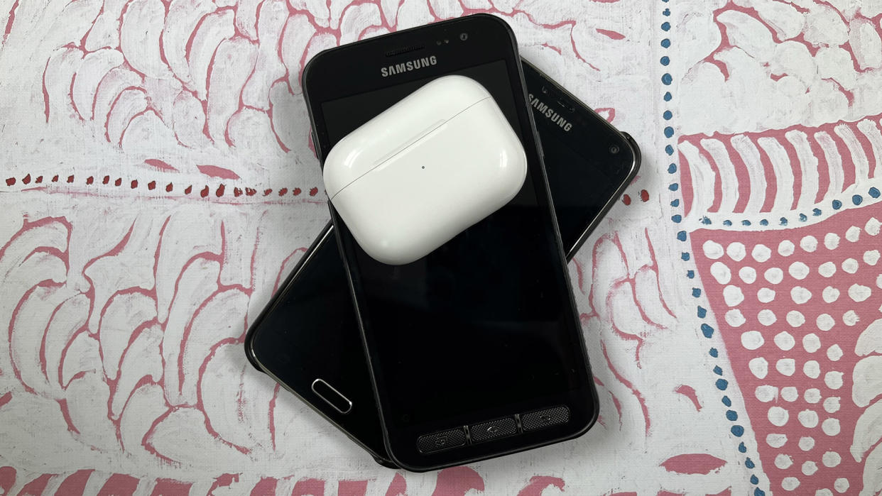  A pair of AirPods sit on top of two stacked Samsung phones. 