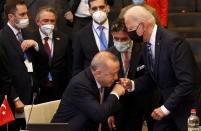 Turkey's President Recep Tayyip Erdogan, center, fist bumps with U.S. President Joe Biden, right, as he stands up to greet him during a plenary session at a NATO summit in Brussels, Monday, June 14, 2021. U.S. President Joe Biden is taking part in his first NATO summit, where the 30-nation alliance hopes to reaffirm its unity and discuss increasingly tense relations with China and Russia, as the organization pulls its troops out after 18 years in Afghanistan. (AP Photo/Olivier Matthys, Pool)