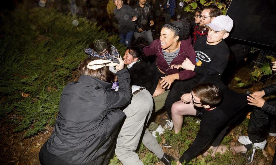 A man pushed by protesters is surrounded as he falls to the ground while leaving a speech by Ann Coulter at the University of California, Berkeley, on 20 November.