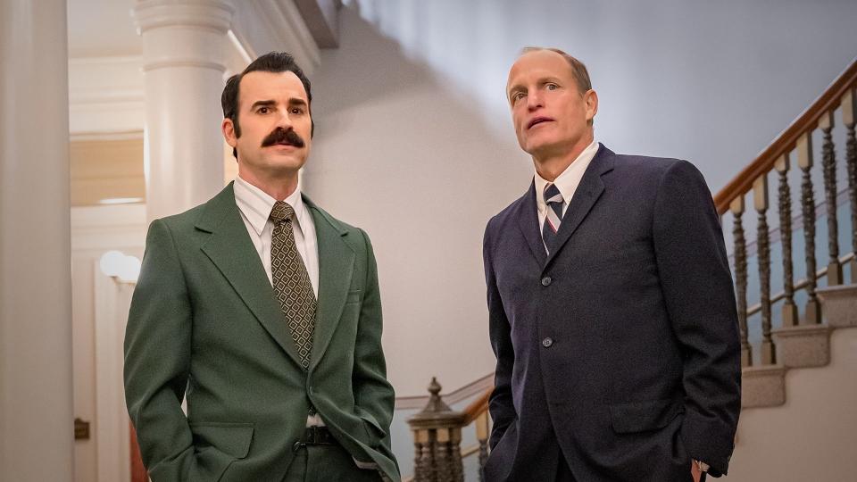 two men by a staircase wearing suits