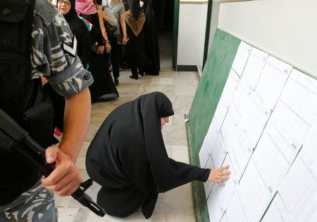 A woman looks at voter's registry at a polling station during the parliamentary election, in Beirut, Lebanon, May 6, 2018. REUTERS/Mohamed Azakir