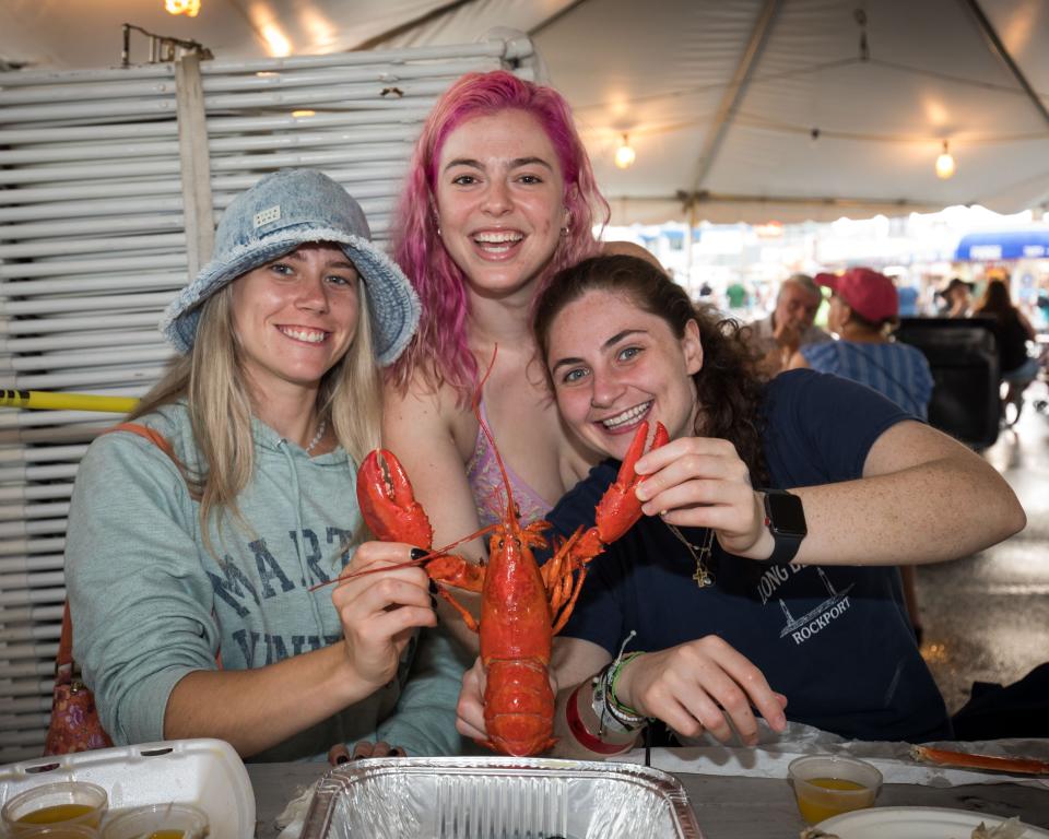 College friends Lindsey Scheivert, AJ Schejtman and Allison Mozzicato show off their cooked red lobster at the 34th annual Hampton Beach Seafood Festival.