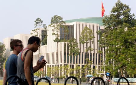 Tourists walk past Vietnam's National Assembly (Parliament) building in Hanoi, Vietnam, September 16, 2016. REUTERS/Kham