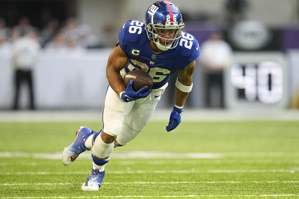 New York Giants running back Saquon Barkley carries the ball up field during the first half of an NFL football game against the Minnesota Vikings, Saturday, Dec. 24, 2022, in Minneapolis. (AP Photo/Abbie Parr)