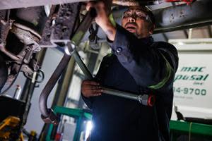 A Casella diesel technician works on a truck.