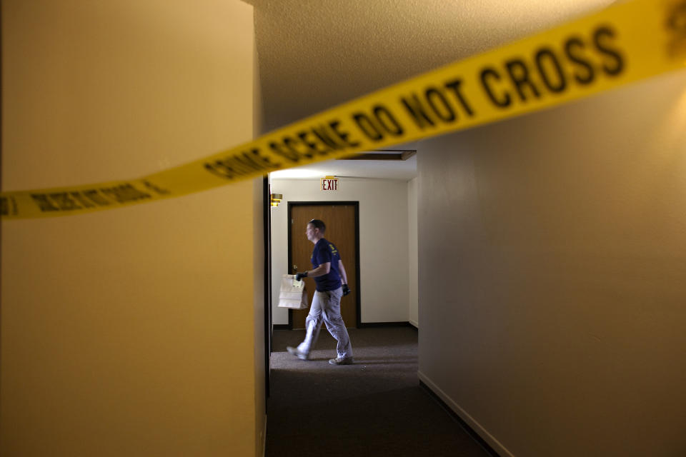 FILE - An FBI Evidence Response Team investigator walks behind crime scene, July 15, 2023, in Fargo, N.D. Data in the FBI's annual crime report released Monday, Oct. 16, 2023 shows that violent crime across the U.S. decreased last year, dropping to about the same level as before the onset of the COVID-19 pandemic. (AP Photo/Ann Arbor Miller, file)