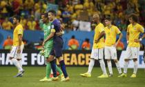 Robin van Persie of the Netherlands walks off the pitch with goalkeeper Michel Vorm, as Brazil players reacts, after their 2014 World Cup third-place playoff at the Brasilia national stadium in Brasilia July 12, 2014. REUTERS/Jorge Silva (BRAZIL - Tags: SOCCER SPORT WORLD CUP)