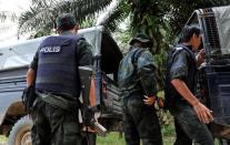 Malaysian police remove the bodies of comrades killed in a mortar attack during a stand-off with Sulu gunmen in Tanduo village, on March 1, 2013. Malaysia has threatened to take "drastic action" against intruding followers of a self-proclaimed Filipino sultan who have vowed to dig in following a shootout that killed 14 people