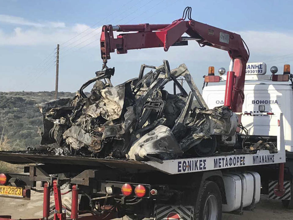 The debris of a car on a crane, following a collision near Greece's northern town of Kavala, Saturday, Oct. 13, 2018. A car carrying migrants collided with a truck in northern Greece on Saturday, killing 11 people, police said. (Proininews.gr via AP)