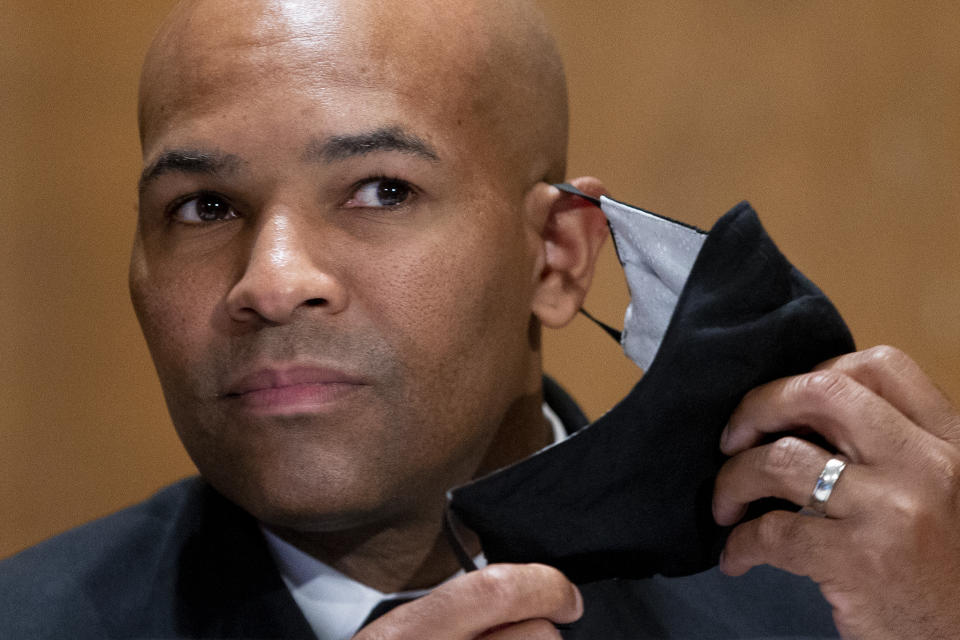 Surgeon General Jerome Adams takes off his face mask as he appears before a Senate Health, Education, Labor and Pensions Committee hearing to discuss vaccines and protecting public health during the coronavirus pandemic on Capitol Hill, Wednesday, Sept. 9, 2020, in Washington. (Michael Reynolds/Pool via AP)