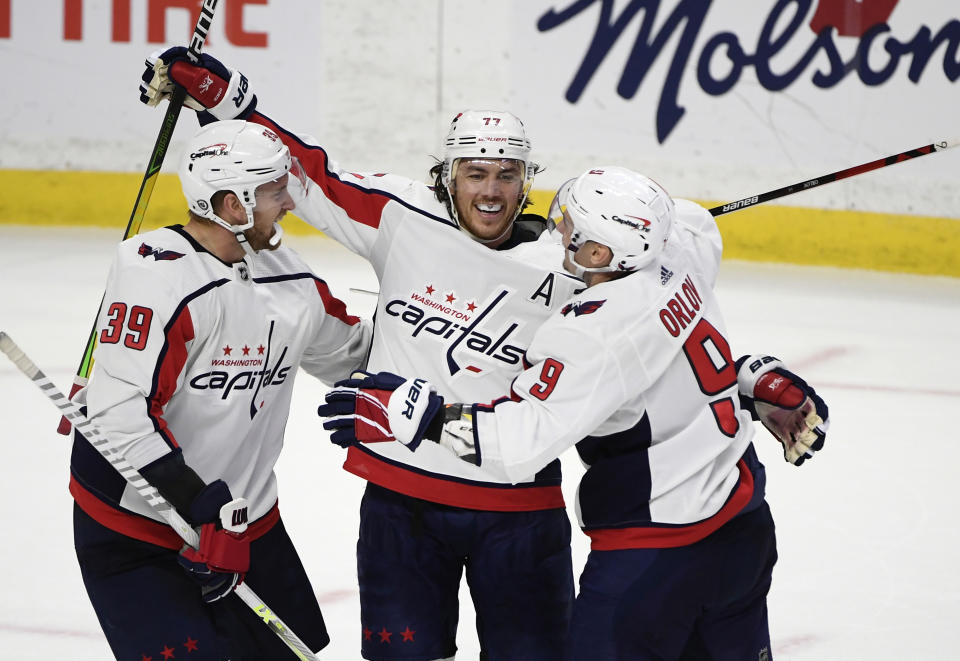 Washington Capitals right wing T.J. Oshie (77) celebrates his hat trick goal against the Ottawa Senators with right wing Anthony Mantha (39) and defenseman Dmitry Orlov (9) during second-period NHL hockey game action in Ottawa, Ontario, Monday, Oct. 25, 2021. (Justin Tang/The Canadian Press via AP)