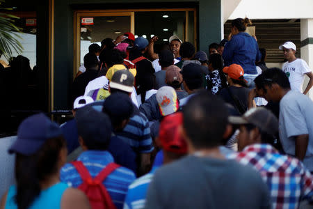 A group of Central American migrants, moving in a caravan through Mexico, arrive at the office of Mexico's National Institute of Migration to start the legal process and get temporary residence status for humanitarian reasons, in Hermosillo, Sonora state, Mexico April 24, 2018. REUTERS/Edgard Garrido