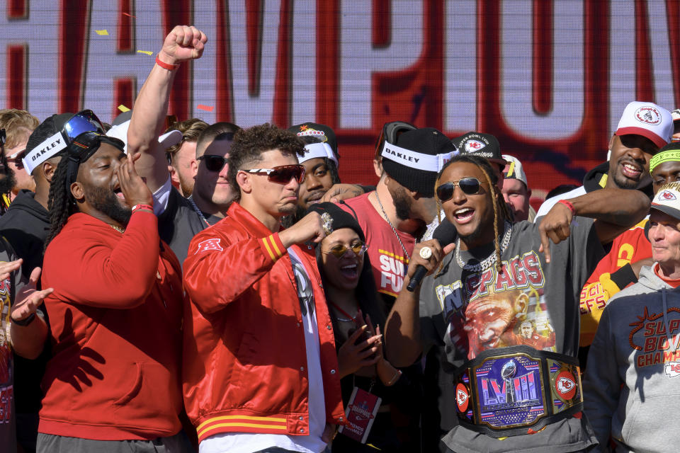 El safety de los Kansas City Chiefs, Justin Reid, a la derecha, se dirige a los fans mientras el mariscal de campo Patrick Mahomes, centro, y el tackle defensivo Derrick Nnadi, observan durante su celebración por la victoria en el Super Bowl. / Foto: AP Photo/Reed Hoffmann