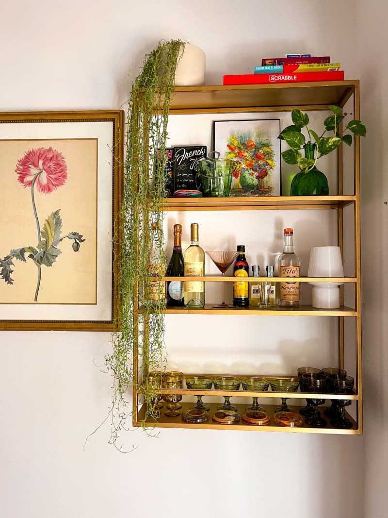 <span>And one final angle from the dining room-- I'm so happy with how this bar shelf from Ballard Designs turned out! The glassware is from Facebook marketplace and green vase is from Mother of Junk in Williamsburg. Also-- my biggest accomplishment of 2023 was realizing how easy it is to propagate plants so I can have them all around the apartment :) Credit: Sarah M</span> <span class="copyright">Credit: Sarah M</span>