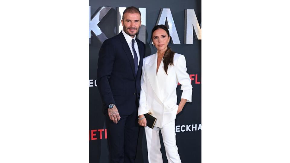 David Beckham in blue suit with Victoria Beckham in a white suit