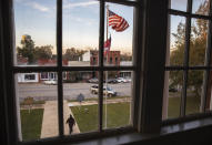 A resident leaves a meeting at the Stewart County courthouse on the town square, Tuesday, Nov. 12, 2019, in Lumpkin, Ga. A mile and a half from the Stewart Detention Center ICE facility, the well-preserved county courthouse, a large red brick building in the classical style with imposing white columns, sits in the center of a tidy lawn with a monument to Confederate soldiers in a shaded corner. It's ringed by commercial buildings, almost all of them empty or closed, even during the business hours posted in the windows. (AP Photo/David Goldman)