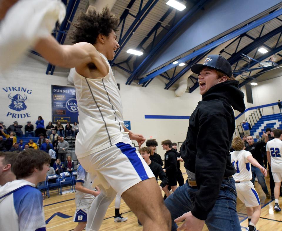 Dundee's Braiden Whitaker leaps to celebrate with Cooper Buhl after the Vikings beat Ida 53-51 in the Division 2 District final on March 10, 2023.