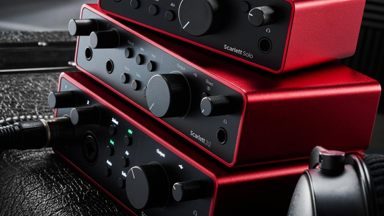  Three Focusrite Scarlett 4th Gen audio interfaces stacked on top of each other in a studio. 