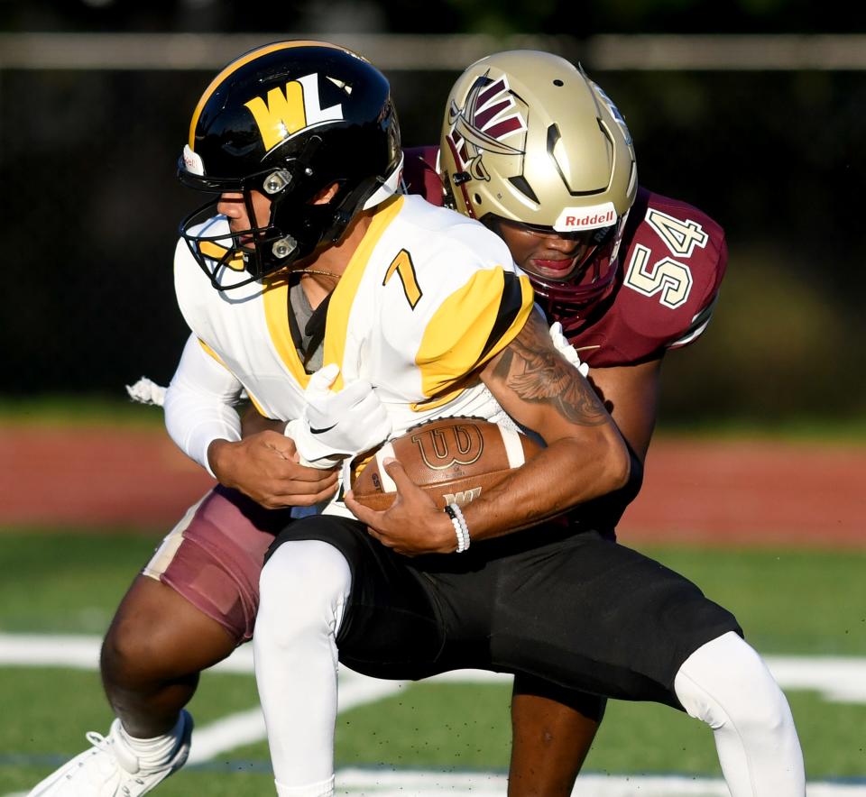 Walsh outside linebacker Nate Watkins brings down West Liberty quarterback Rudy Garcia in the first quarter of Thursday's season opener.