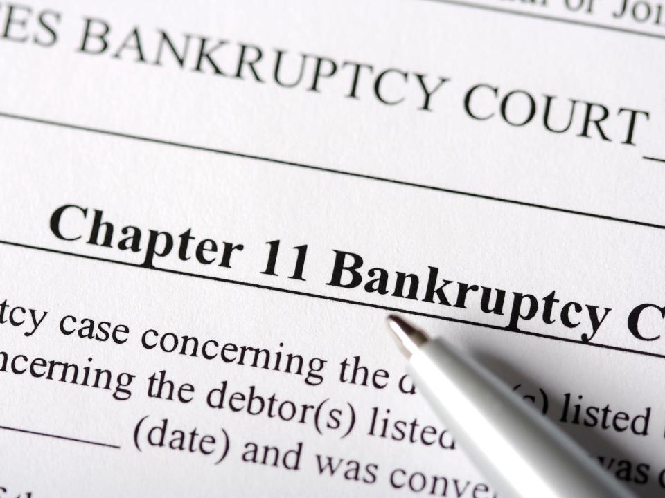 A pen on top of a paper that says "Chapter 11 Bankruptcy."