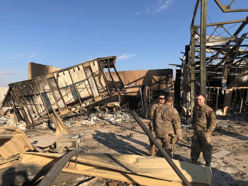 U.S. soldiers stand at the site where an Iranian missile hit at Ain al-Asad air base in Anbar province