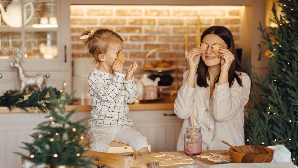 happy daughter and beautiful mother preparing christmas cookies in kitchen at home