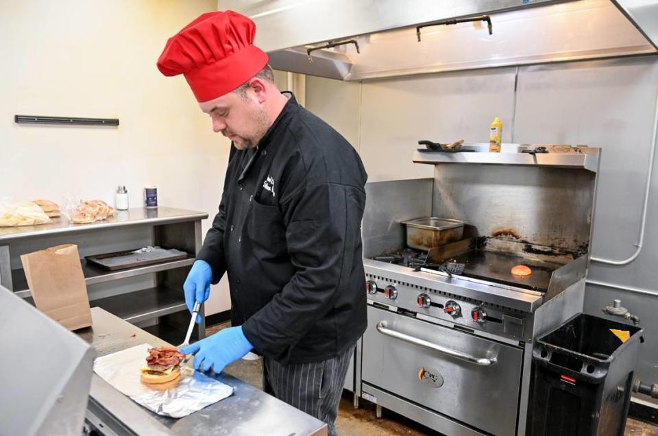 In this Telegraph file photo, Jonathan Keene, owner of Keen’s Kafe, puts together a “Keene’s Famous” steak burger. The burger includes two Angus steak patties, muenster cheese, bacon, lettuce, red onion and pickles on a brioche bun along with a side of fries.