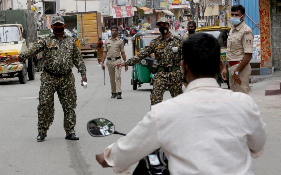 Indian policemen stop motorists for violating the rules and people not wearing the protective masks during an extended lockdown - JAGADEESH NV/EPA-EFE/Shutterstock/Shutterstock