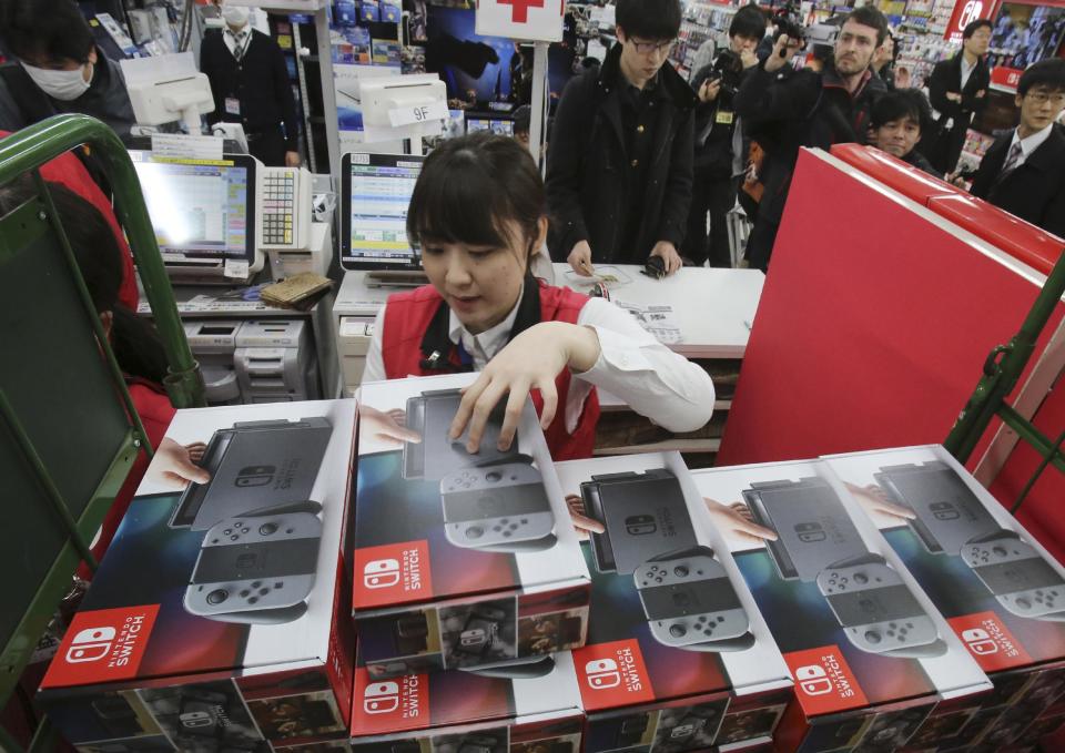 Employee of the electronics retailer Bic Camera sells Nintendo's newest computer game "Switch" at a retail store in central Tokyo. Friday, March 3, 2017. (AP Photo/Koji Sasahara)