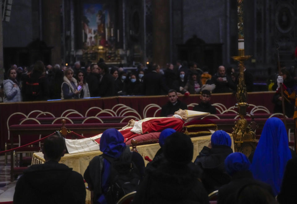 The body of late Pope Emeritus Benedict XVI is lied out in state inside St. Peter's Basilica at The Vatican where thousands went to pay their homage. Pope Benedict, the German theologian who will be remembered as the first pope in 600 years to resign, has died, the Vatican announced Saturday, Dec. 31, 2022. He was 95. (AP Photo/Gregorio Borgia)