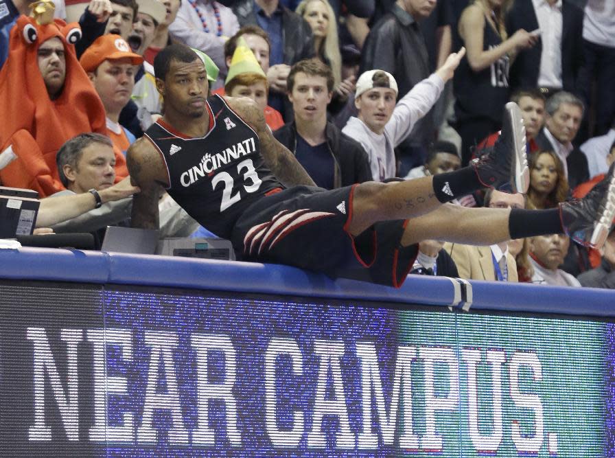 Cincinnati guard Sean Kilpatrick lands on the scorer's tables after chasing a loose ball during the first half of an NCAA college basketball game against SMU on Saturday, Feb. 8, 2014, in Dallas. (AP Photo/LM Otero) vcb