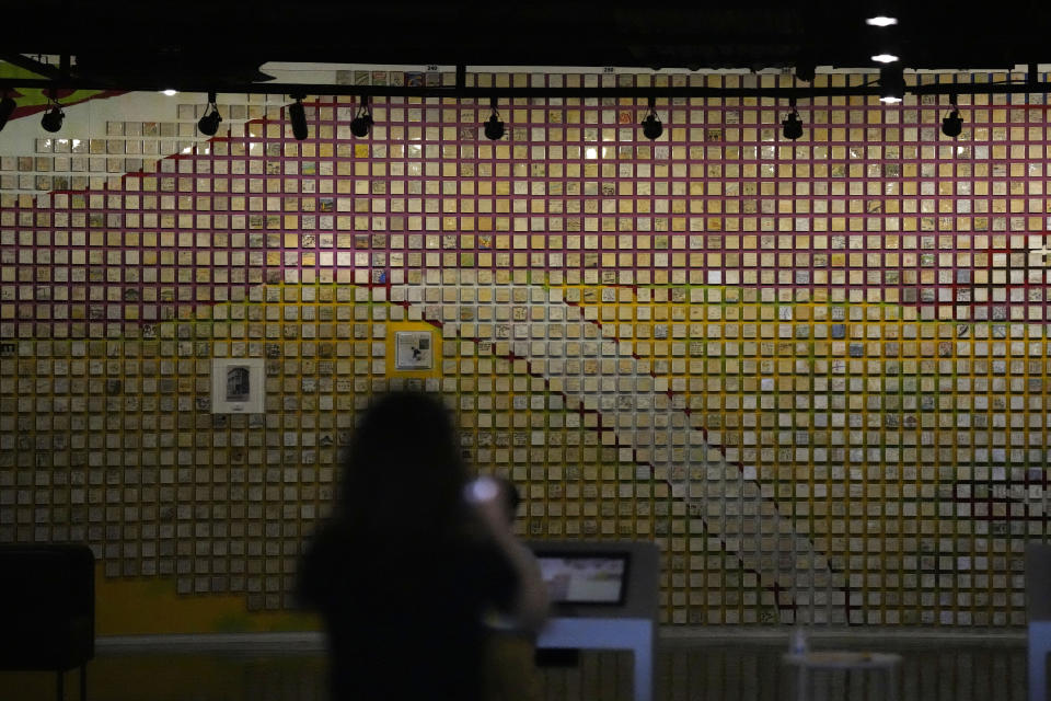 A visitor takes a photo of a wall displayed with messages and painting for families separated at the exhibition hall of the unification observatory in Paju, South Korea, Thursday, Sept. 8, 2022. South Korea's new government on Thursday proposed a meeting with North Korea to resume reunions of families separated since the 1950-53 Korean War, despite long-strained ties between the rivals over the North's nuclear weapons program. (AP Photo/Lee Jin-man)