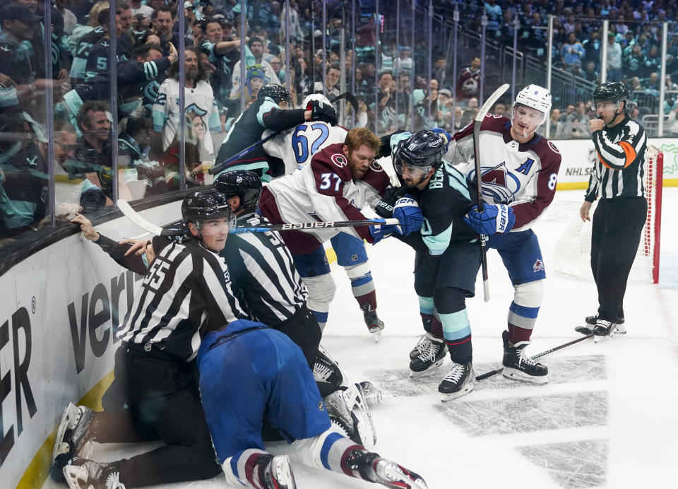 Officials try to separate players as the Seattle Kraken and the Colorado Avalanche fight during the second period of Game 6 of an NHL hockey Stanley Cup first-round playoff series Friday, April 28, 2023, in Seattle. (AP Photo/Lindsey Wasson)