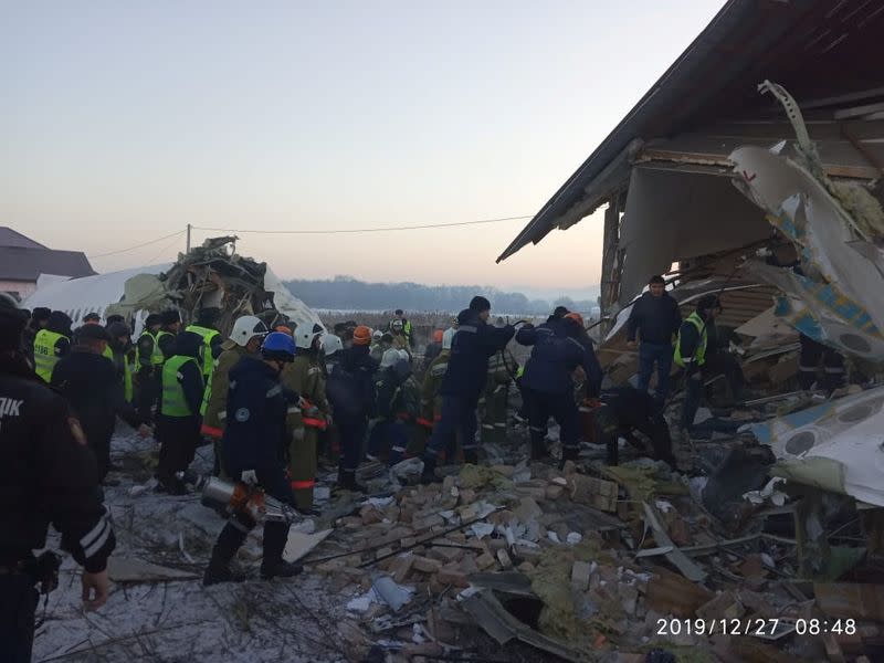 Emergency and security personnel are seen at the site of the plane crash near Almaty