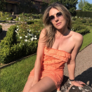 <p>The actor and designer poses in a strapless mini dress in an English garden, writing “Last of the tulips on a perfect Saturday in May.” Her apricot dress is available from her line, and retails for $99. (Photo: Instagram/ </p>