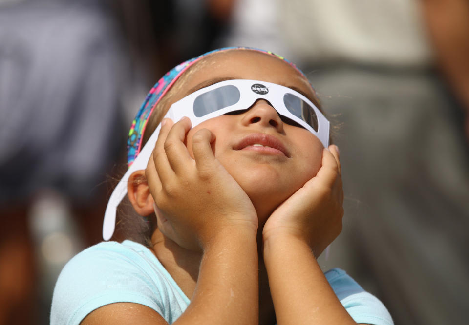 A young spectator looks skyward during a partial eclipse of the sun at the Cradle of Aviation Museum in Garden City, New York. (Photo: Bruce Bennett/Getty Images)