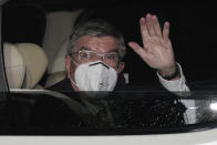 International Olympic Committee (IOC) President Thomas Bach waves from the vehicle to media upon his arrival an accommodation Thursday, July 8, 2021, in Tokyo. Bach arrived on Thursday, July 8, 2021, in Tokyo as Japan Prime Minister Yoshihde Suga was set to declare a state of emergency that is likely to result in a ban on fans from the Tokyo Olympics as coronavirus infections spread across the capital. (AP Photo/Eugene Hoshiko, Pool)