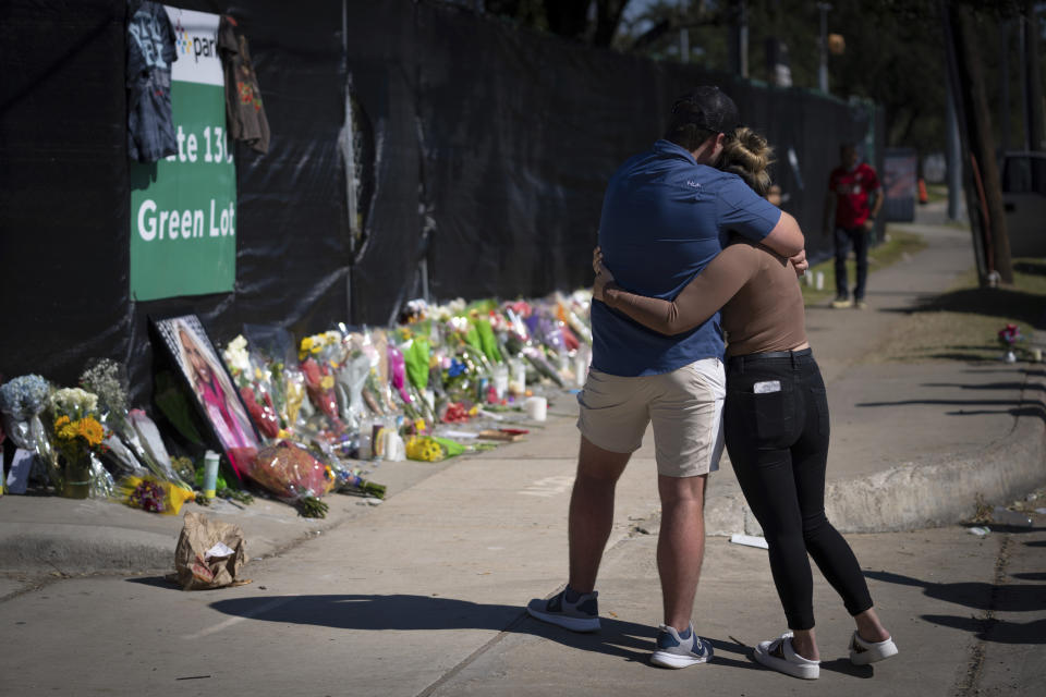 FILE - Two people who knew an unidentified victim of a fatal incident at the Houston Astroworld concert embrace at a memorial on Nov. 7, 2021, in Houston. The families of two people who died during last year's deadly Astroworld music festival have settled wrongful death lawsuits they had filed, according to attorneys. (AP Photo/Robert Bumsted, File)