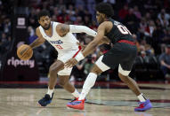 Los Angeles Clippers forward Paul George, left, dribbles the ball around Portland Trail Blazers guard Scoot Henderson during the second half of an NBA basketball game in Portland, Ore., Wednesday, March 20, 2024. (AP Photo/Craig Mitchelldyer)