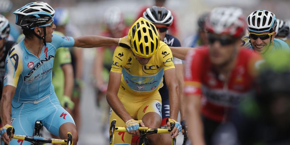 2014 Tour de France cycling race winner Italy's Vincenzo Nibali, wearing the overall leader's yellow jersey, is congratulated by teammates as he crosses the finish line of the twenty-first and last stage of the Tour de France cycling race over 137.5 kilometers (85.4 miles) with start in Evry and finish in Paris, France, Sunday, July 27, 2014. (AP Photo/Laurent Rebours)