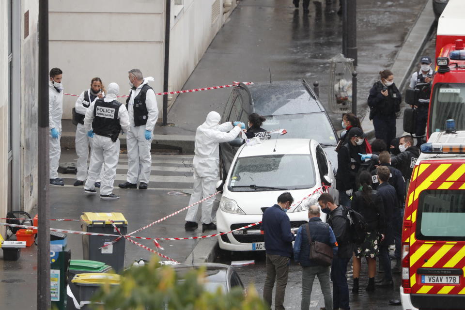 FILE - In this Sept. 25, 2020 file photo, police and forensic investigate an attack that wounded two people near the former offices of the satirical newspaper Charlie Hebdo, in Paris, France. Ali Hassan, from the Pakistani village of Kotli Qazi, deep in a rural area of Punjab province, is in jail in Paris for allegedly attacking and seriously wounding the two people. Before the attack, Hassan proclaimed in a video that he was seeking vengeance after Charlie Hebdo republished caricatures of Islam’s Prophet Muhammad. (AP Photo/Thibault Camus, File)