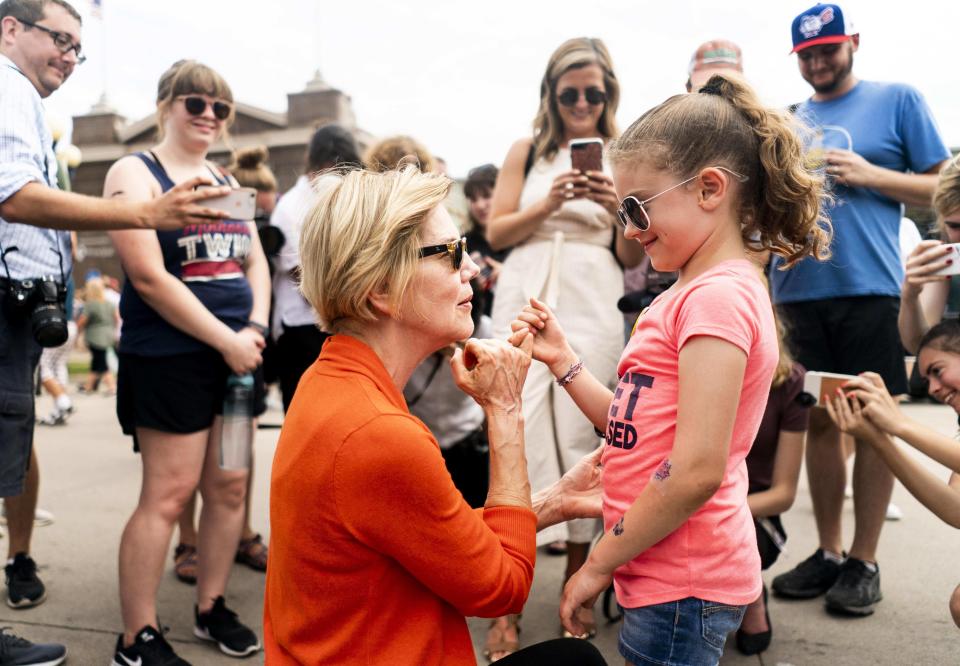 Elizabeth Warren and a supporter do a pinky-promise at the Iowa State Fair in August 2019.