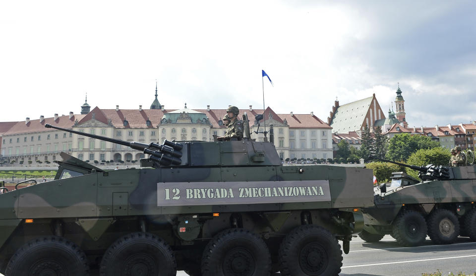 Armoured vehicles roll on one of the city's main streets during a yearly military parade celebrating the Polish Army Day in Warsaw, Poland, Wednesday, Aug. 15, 2018, with the Royal Castle in the background. Poland marks Army Day with a parade and a call for US permanent military base in Poland. (AP Photo/Alik Keplicz)