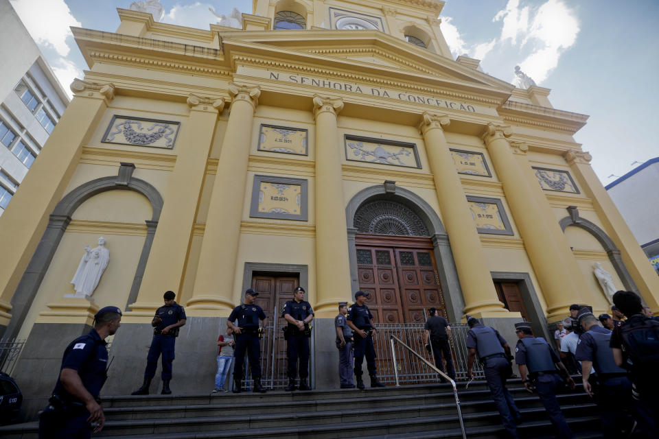 Police stand guard outside the Metropolitan Cathedral after a deadly shooting in Campinas, Brazil, Tuesday, Dec. 11, 2018. A man opened fire in the cathedral in southern Brazil after Mass on Tuesday, killing four and leaving four others injured before taking a bullet in the ribs in a firefight with police and then shooting himself in the head, authorities said. (AP Photo/Victor R. Caivano)