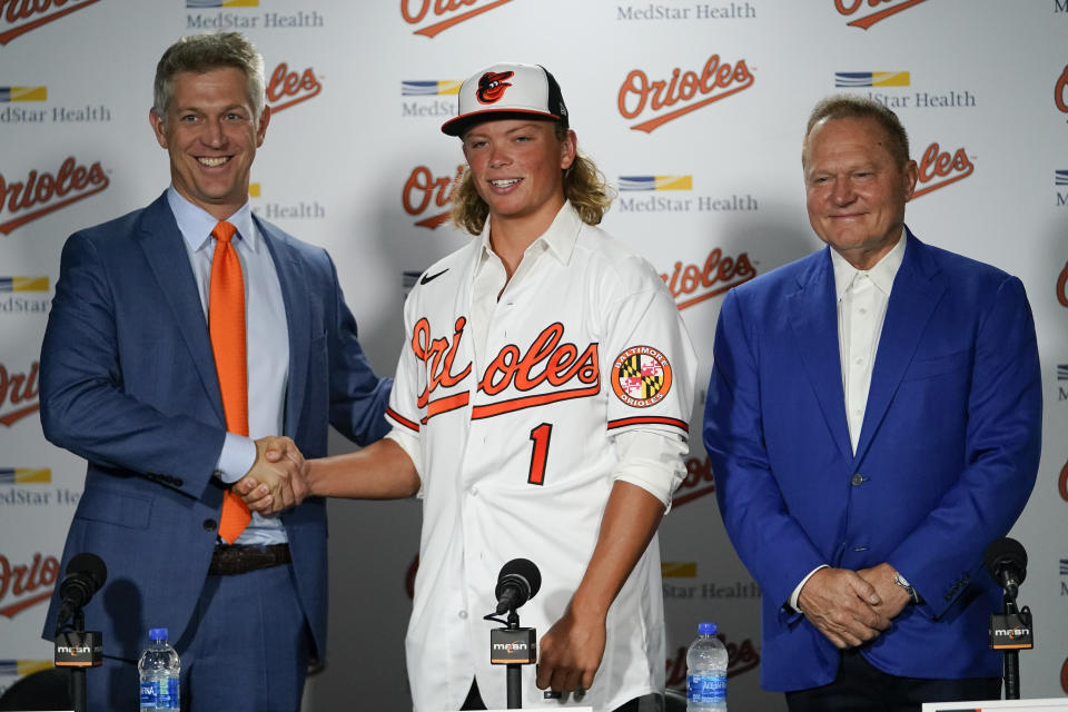 CORRECTS DATE - Jackson Holliday, center, the first overall draft pick by the Baltimore Orioles in the 2022 draft, poses for photos with general manager Mike Elias, left, and agent Scot Boras during a news conference introducing him to the Baltimore media prior to a baseball game between the Baltimore Orioles and the Tampa Bay Rays, Wednesday, July 27, 2022, in Baltimore. (AP Photo/Julio Cortez)