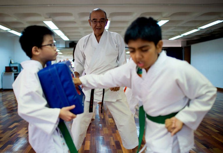Shigeru Tanida (C) is seen supervising karate students in Kuala Lumpur, on November 3, 2012. Tanida, 65, has lived in Malaysia's capital Kuala Lumpur since 2006, drawn by the year-round sunshine and far lower living costs than in Japan. With its warm climate, political stability and modern economy, Malaysia has drawn 19,488 foreigners to settle in the country during the past 10 years