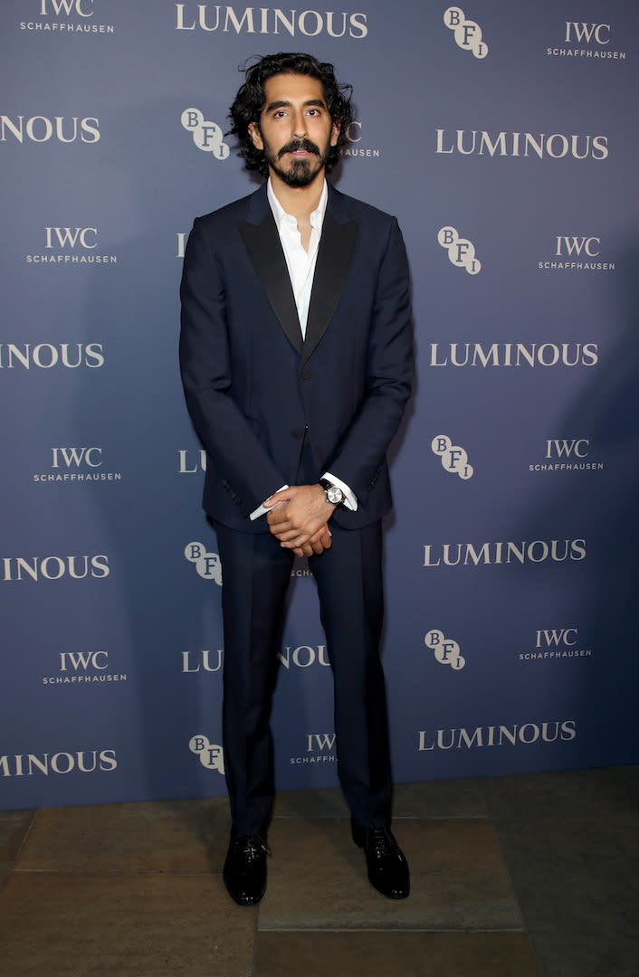 Wearing a navy suit with a relaxed white shirt peeping from beneath. <em>[Photo: Getty]</em>