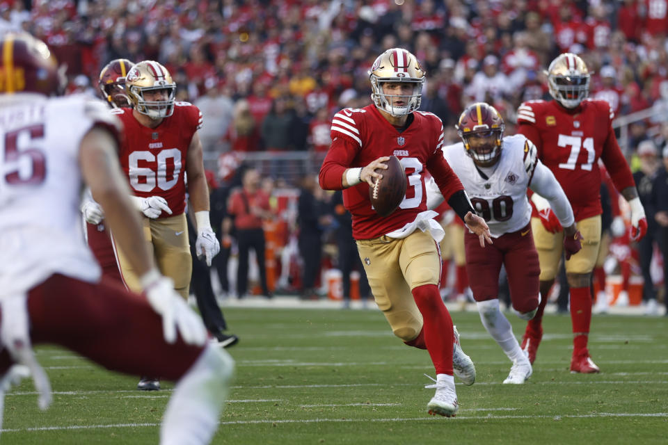 San Francisco 49ers quarterback Brock Purdy (13) rushes the ball in the second half of an NFL football game against the Washington Commanders, Saturday, Dec. 24, 2022, in Santa Clara, Calif. (AP Photo/Jed Jacobsohn)