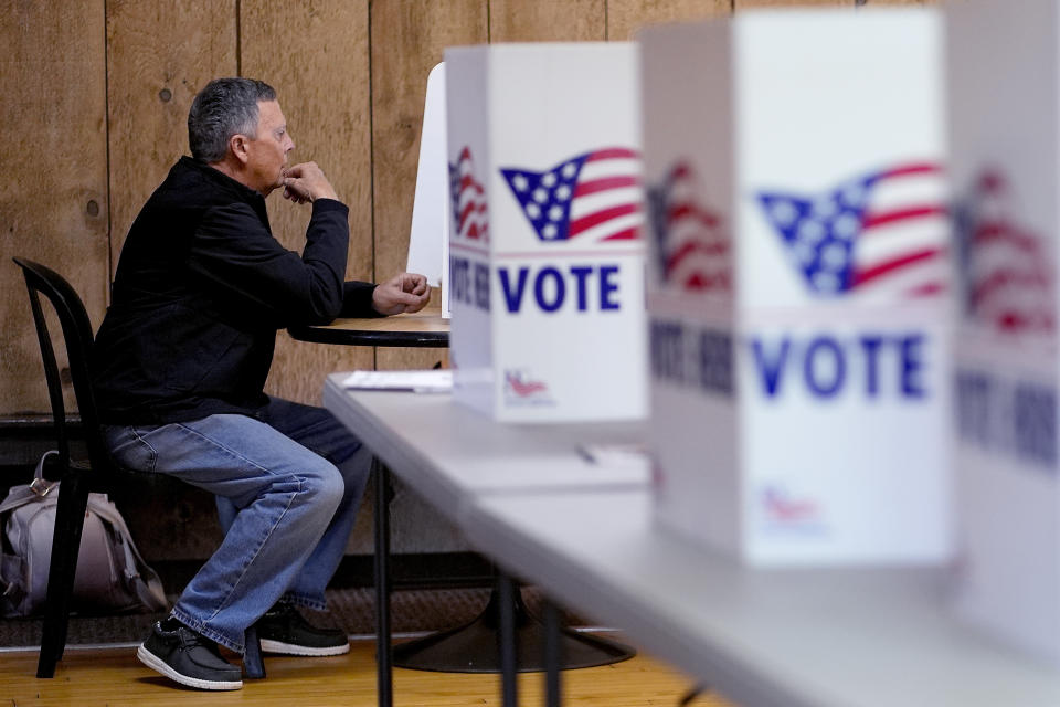 A man votes Tuesday, April 2, 2024, at Yellow Rock Barn in Kansas City, Mo. Voters are being asked to decide whether to extend a sales tax to fund a new baseball stadium for the Kansas City Royals and football stadium improvements for the Kansas City Chiefs. (AP Photo/Charlie Riedel)