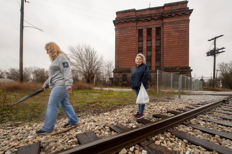 Joanie Markle, left and Deb Etter walk the railroad tracks in front of the vacant, former York County prison building. 